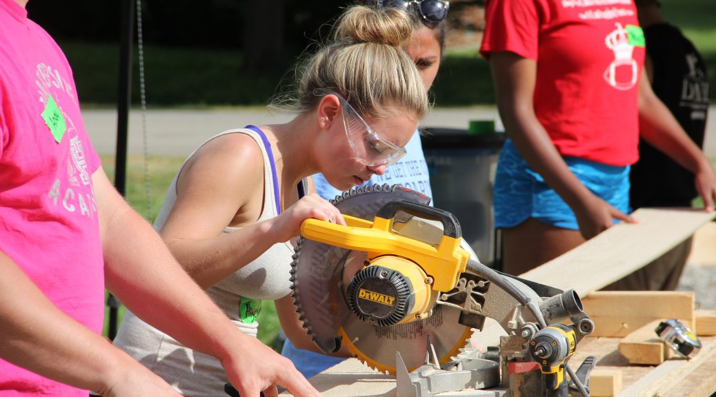 Student operating a stationary saw during her senior project